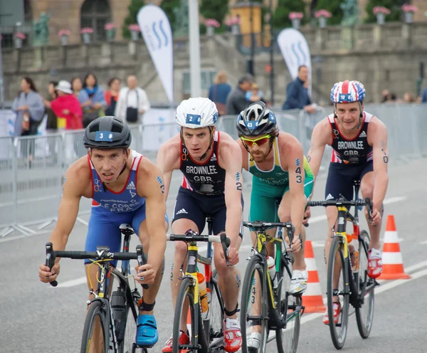 Brownlee bröder och grupp färgstarka manliga triathlet cyklister — Stockfoto