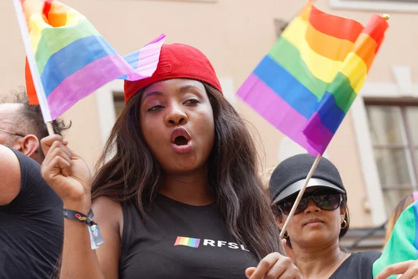 Mujer renunciando al colorido arco iris Bandera del Orgullo en el desfile del Orgullo — Foto de Stock