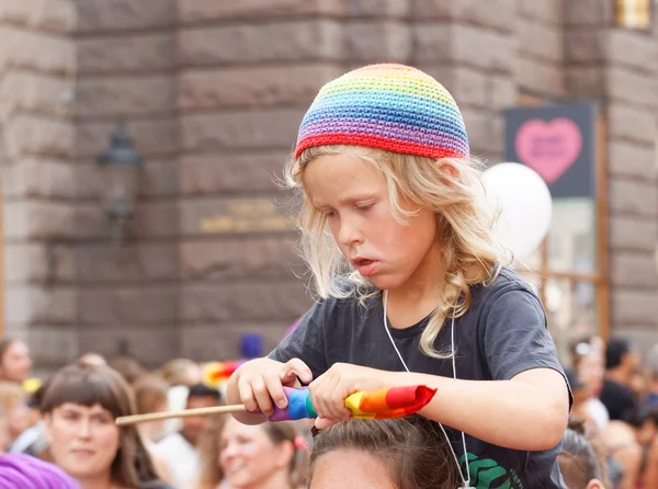 Sarışın küçük çocuk gurur geçit töreninde bir gökkuşağı şapka — Stok fotoğraf