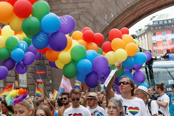 Szczęśliwi ludzie gospodarstwa balony kolorowe w kolorze czerwonym, wzruszający i niebieski — Zdjęcie stockowe