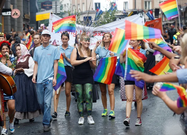 Młodzi, szczęśliwy dziewcząt i chłopców, zrzekając się rainbow pride flagi — Zdjęcie stockowe
