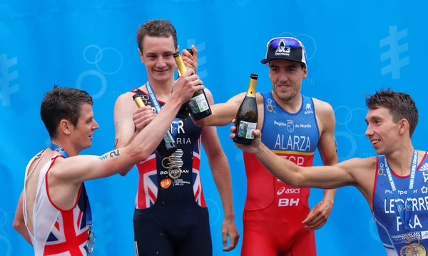 The medalist triathletes drinking champagne on the podium — Stock Photo, Image