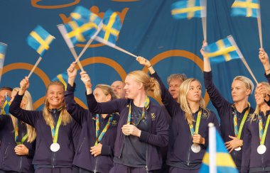 İsveç bayraklarını sallayarak mutlu İsveçli kadın futbol takımı