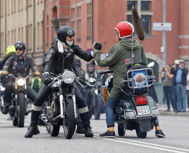 Motosiklet ve vespa el sıkışan iki adam