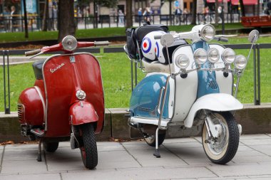 İki güzel kırmızı ve mavi/beyaz retro vespa scooter Park