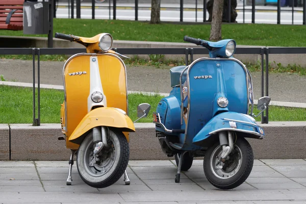一个黄色和一个蓝色复古 vespa 摩托车停放 — 图库照片