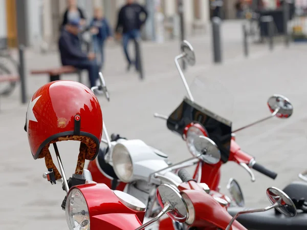 Rot glänzender Retro-Helm am Lenker eines Vespa-Motorrollers — Stockfoto