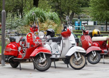 Üç güzel kırmızı ve beyaz retro vespa scooter park