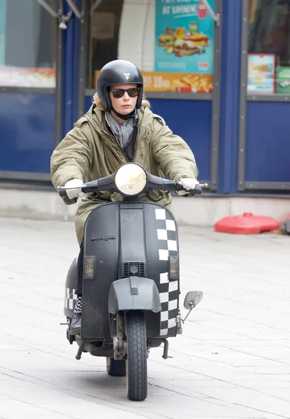 Mods woman driving a black retro vespa scooter — Stock fotografie