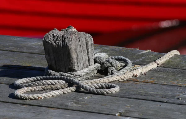 Bollard and red fishing boat — Stock Photo, Image