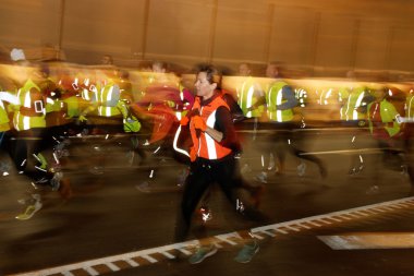 Koşucular renkli giysiler içinde bir sürü