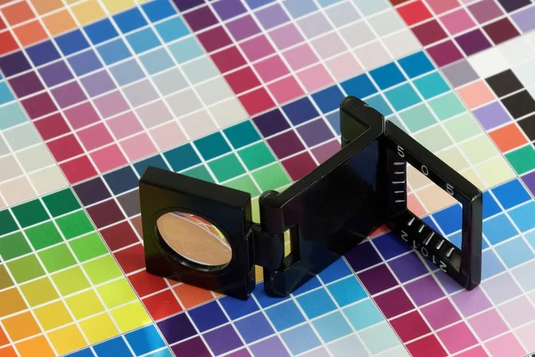 Close-up of a loupe on a colorful test print — Stock Photo, Image