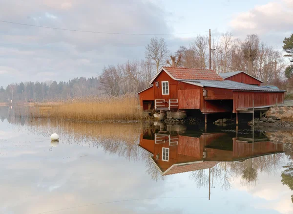 Röda båthus, lugnt hav — Stockfoto