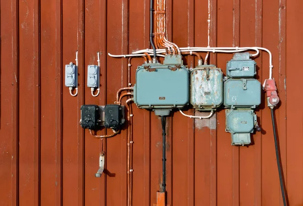 Electric junction boxes, retro style on red wall — Stock Photo, Image