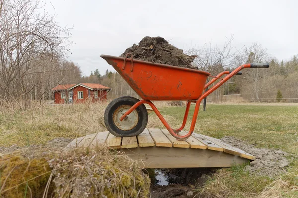 Wheel barrow full of mud — Stock Photo, Image