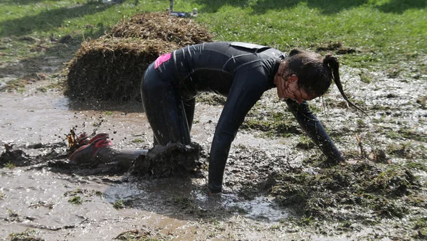 Mujer arrastrándose de rodillas a través del barro — Foto de Stock