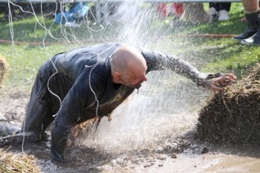 Man fighting to get through the mud, squirted with water, electr clipart