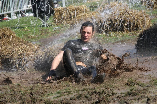 Hombre cayendo en el barro chorreado con agua — Foto de Stock