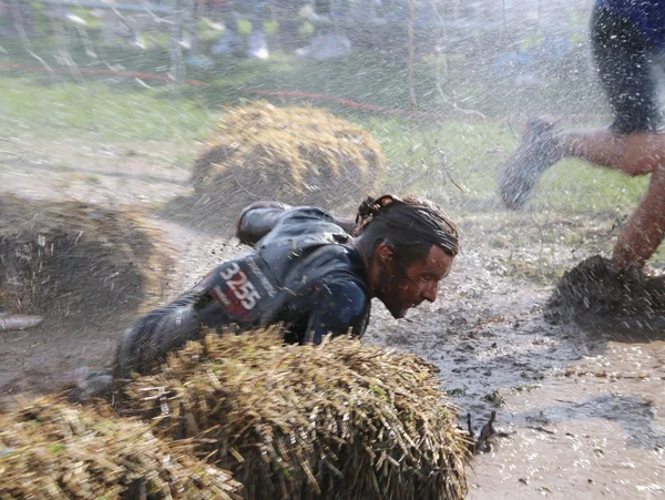 泥や水で吹き出される泥の中の男性が陥っています。 ストック画像