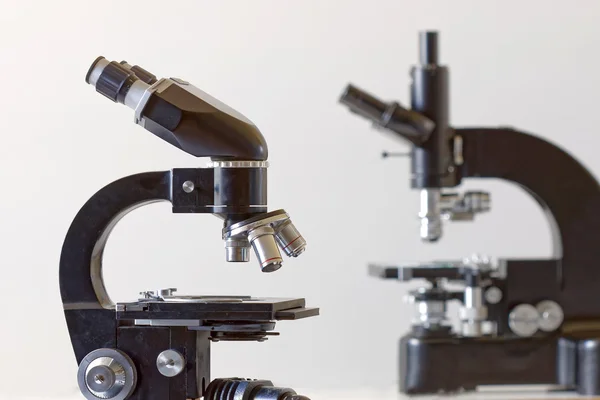 Two black vintage microscopes, side view — Stock Photo, Image