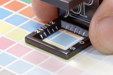 Yakın çekim bir büyüteç ve el renkli test yazdırma