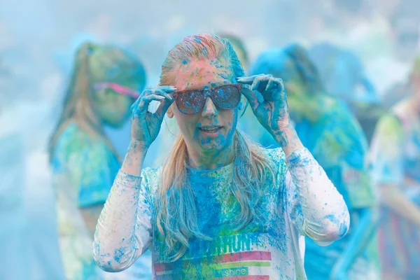 Młoda kobieta pokryte kolor niebieski proszek mocowania okularów — Zdjęcie stockowe