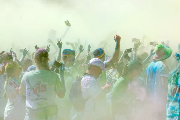 El participante en la Carrera de Color renunciando a los brazos en el cielo — Foto de Stock