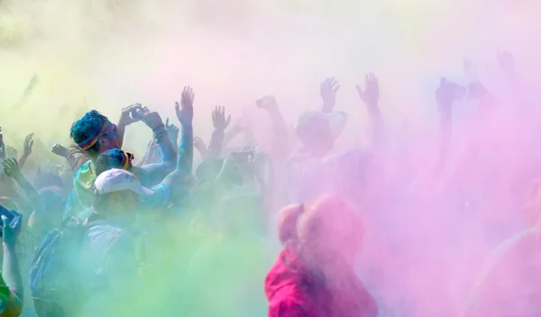 Los participantes en el Color Run renunciando a los brazos en el cielo — Foto de Stock