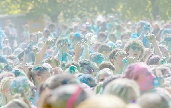 O participante na corrida de cores renunciando os braços no céu — Fotografia de Stock