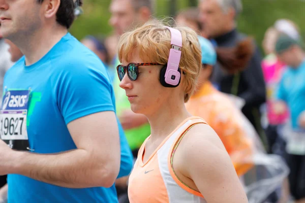 Uma mulher correndo usando fones de ouvido — Fotografia de Stock