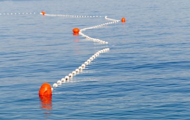 Red markers in the sea marking the safe swimming area clipart