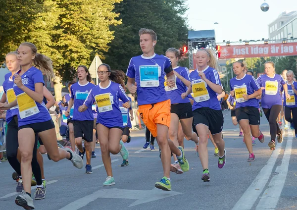 Group of running girls and boys in a curve — Stock Photo, Image