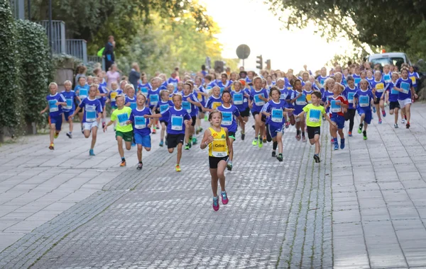 Girl in the lead followed by running competitors — Stock Photo, Image