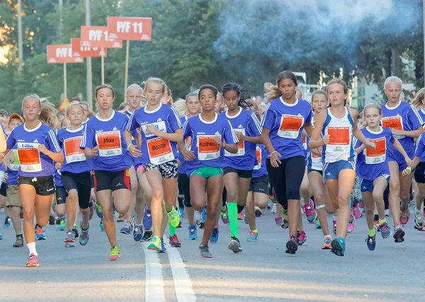 Group of running girls in blue dresses — Stock Photo, Image