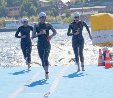 Birçok kadın yüzücü sudan tırmanma