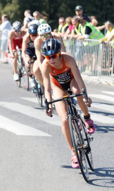 Triathlete Rachel Klamer cycling, followed by competitors clipart