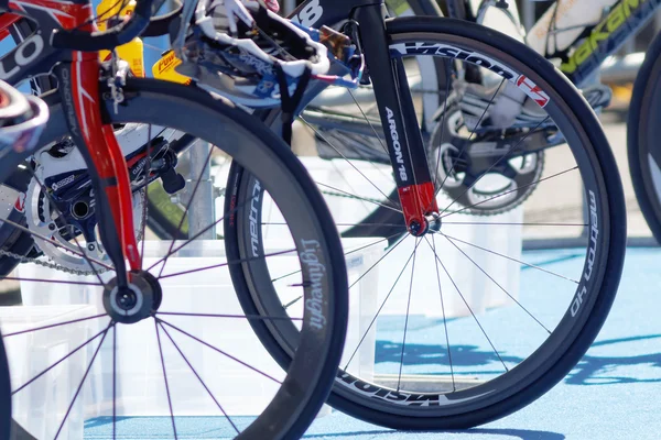 Lots of bicycle wheels on triathlete bicycles