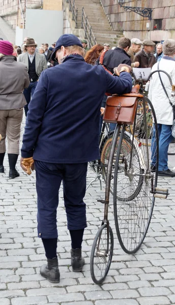 Человек со старым велосипедом в старомодной голубой одежде — стоковое фото
