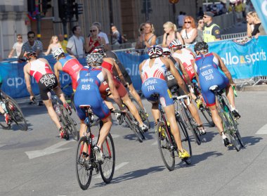 Rear view of large group of male cycling triathlon competitors