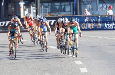 Büyük grup renkli triathletes eğrideki Bisiklete binme