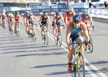 Large group of colorful triathletes cycling