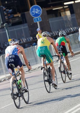 Rear view of three male cycling triathlon competitors