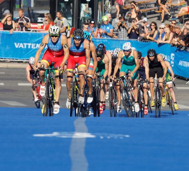 Spanish triathlon competitors cycling uphill clipart