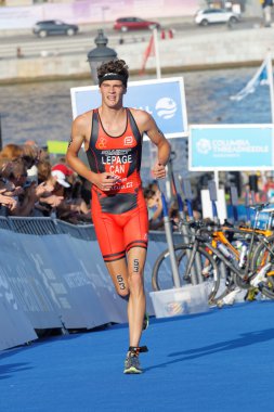 Stockholm, İsveç - 23 Ağustos 2015: Turuncu elbiseli koşucu Alexis Lepage, 23 Ağustos 2015 tarihinde İsveç 'in Stockholm kentinde düzenlenen Erkekler Itu Dünya Triatlon Şampiyonası' nda yokuş yukarı koşuyor.