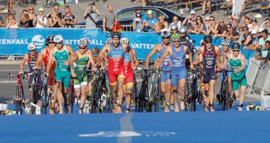 STOCKHOLM, SWEDEN - AUG 23, 2015: Large group of triathletes running uphill in the transition zone from cycling to running in the Men's ITU World Triathlon series event August 23, 2015 in Stockholm, Sweden