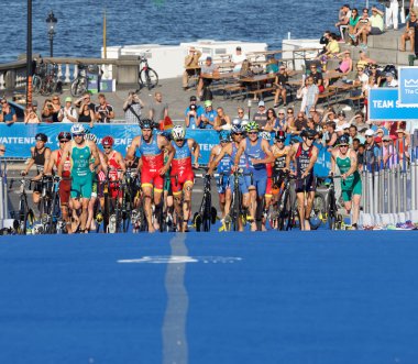 STOCKHOLM, SWEDEN - AUG 23, 2015: Large group of triathletes running uphill in the transition zone from cycling to running in the Men's ITU World Triathlon series event August 23, 2015 in Stockholm, Sweden