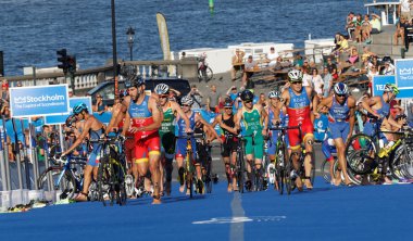 Stockholm, İsveç - 23 Ağustos 2015: Dramatik sceene döngüleri Stokholm, İsveç'te 23 Ağustos 2015 ' Men's İTÜ dünya triatlon serisi olay geçiş bölgesinde otopark triathletes Grubu'nun