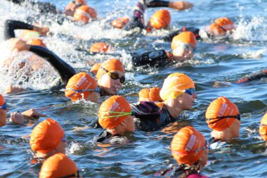 W turuncu banyo kapakları giyen kadın triathletes Grubu
