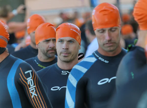 Triathlet mit orangefarbenem Badebecher läuft zum Startbereich — Stockfoto