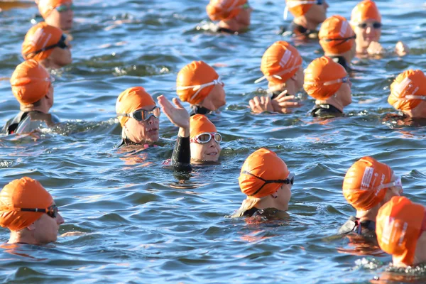 Zwaaiende triatleet met oranje Badmutsen in het water — Stockfoto